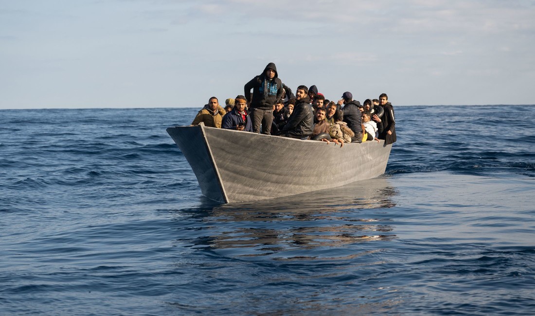 Ein vollbesetztes Holzboot auf dem Mittelmeer. 