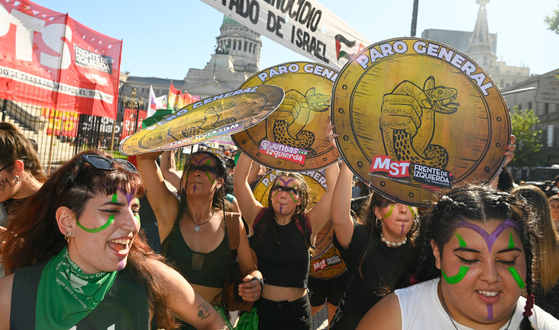 Junge Frauen fordern bei einer Kundgebung zum Internationalen Frauentag am 8. März 2024 vor dem argentinischen Kongress einen "Generalstreik". Auf ihren Schildern wird die Schlange als Symbol der ultraliberalen Bewegung von Präsident Milei am Nacken gepackt.