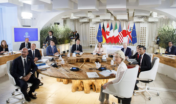 Die Regierungschefs der G7-Staaten sowie die EU-Kommissionspräsidentin Ursula von der Leyen (vorne rechts) und Charles Michel (vorne links), Präsident des Europäischen Rates, sitzen an einem Glastisch und blicken in die Kamera. 