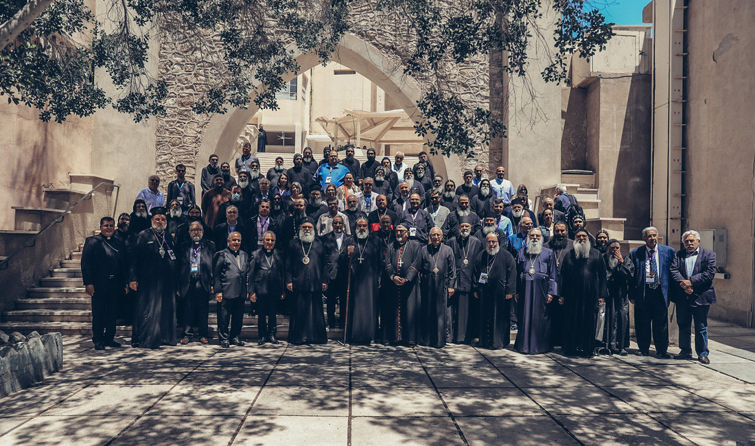 Gruppenfoto kirchlicher Würdenträger vor dem Eingang zu einem Kloster.