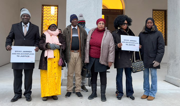 Eine Gruppe vorwiegend afrikanischer Menschen im Eingang eines großen alten Gebäudes.